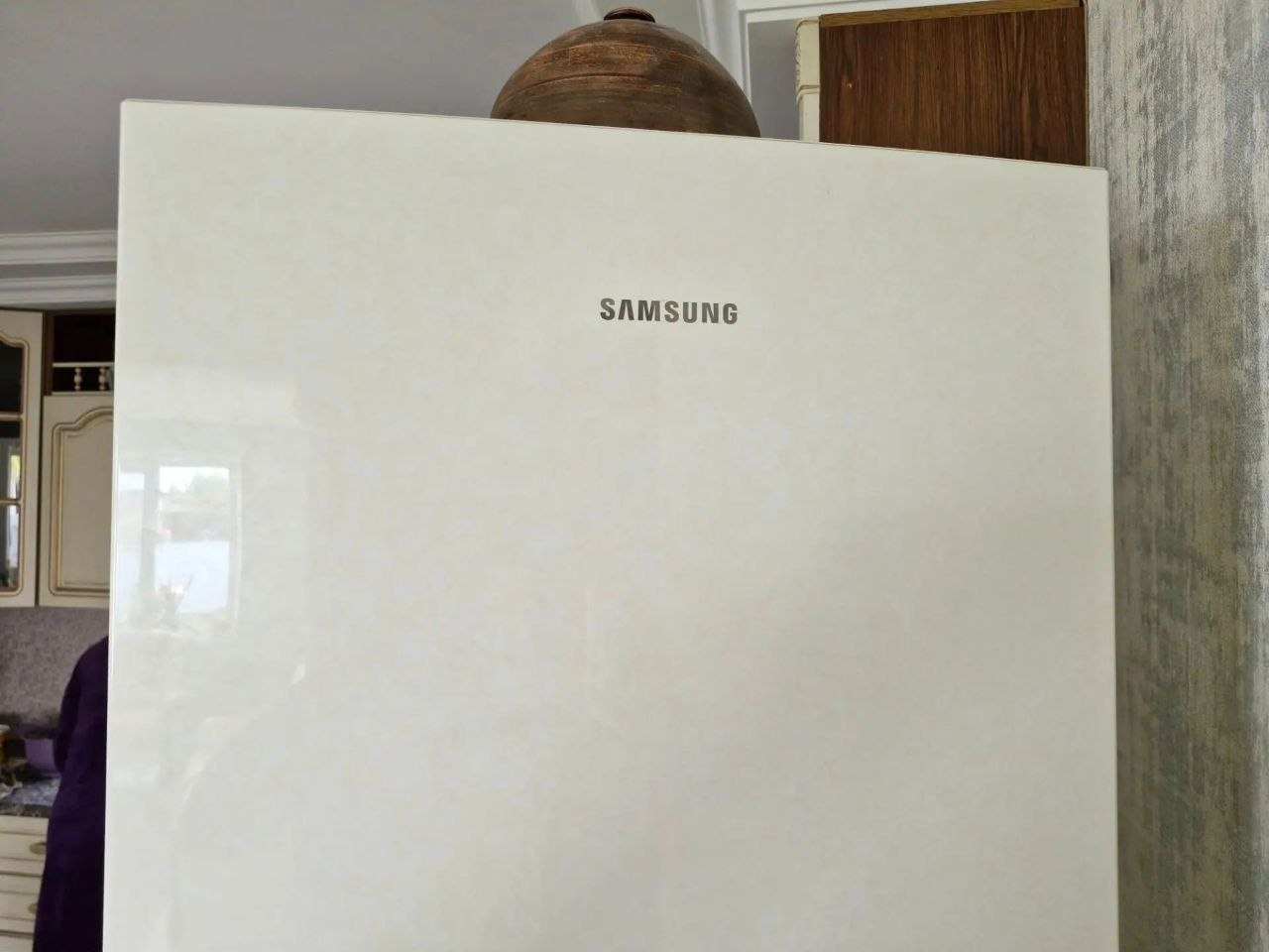 Открытая сервисная панель холодильника Samsung с видимыми электронными платами; снятая плата в руке мастера